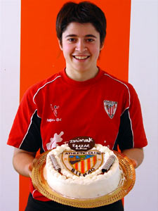 Uguzne posa sonriente con su tarta de cumpleaños