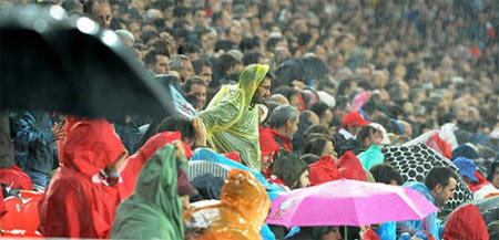 Socios del Athletic con chubasqueros y paraguas un día de lluvia en San Mamés